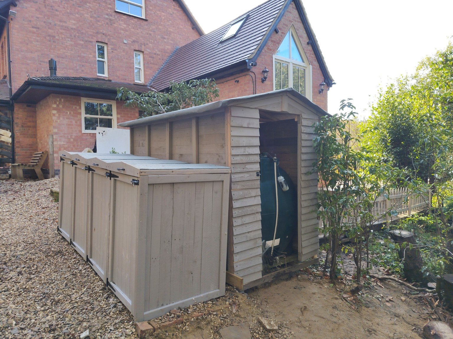 Recycling shelves beside wheelie bin storage